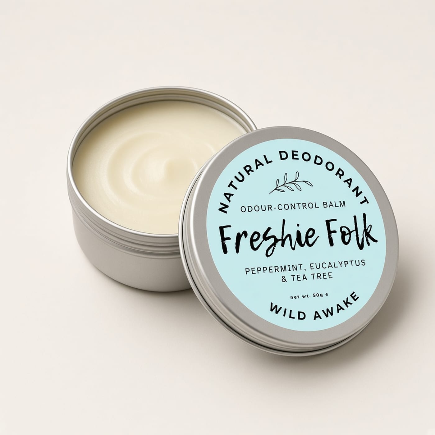 Closed silver tin of Wild Awake deodorant on a warm off-white background.